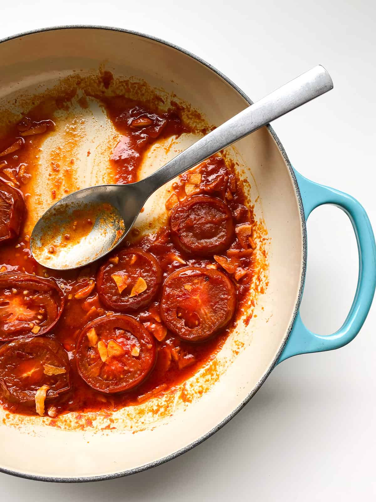 An image of a pan of Easy Garlic Tomatoes that has been partially served.