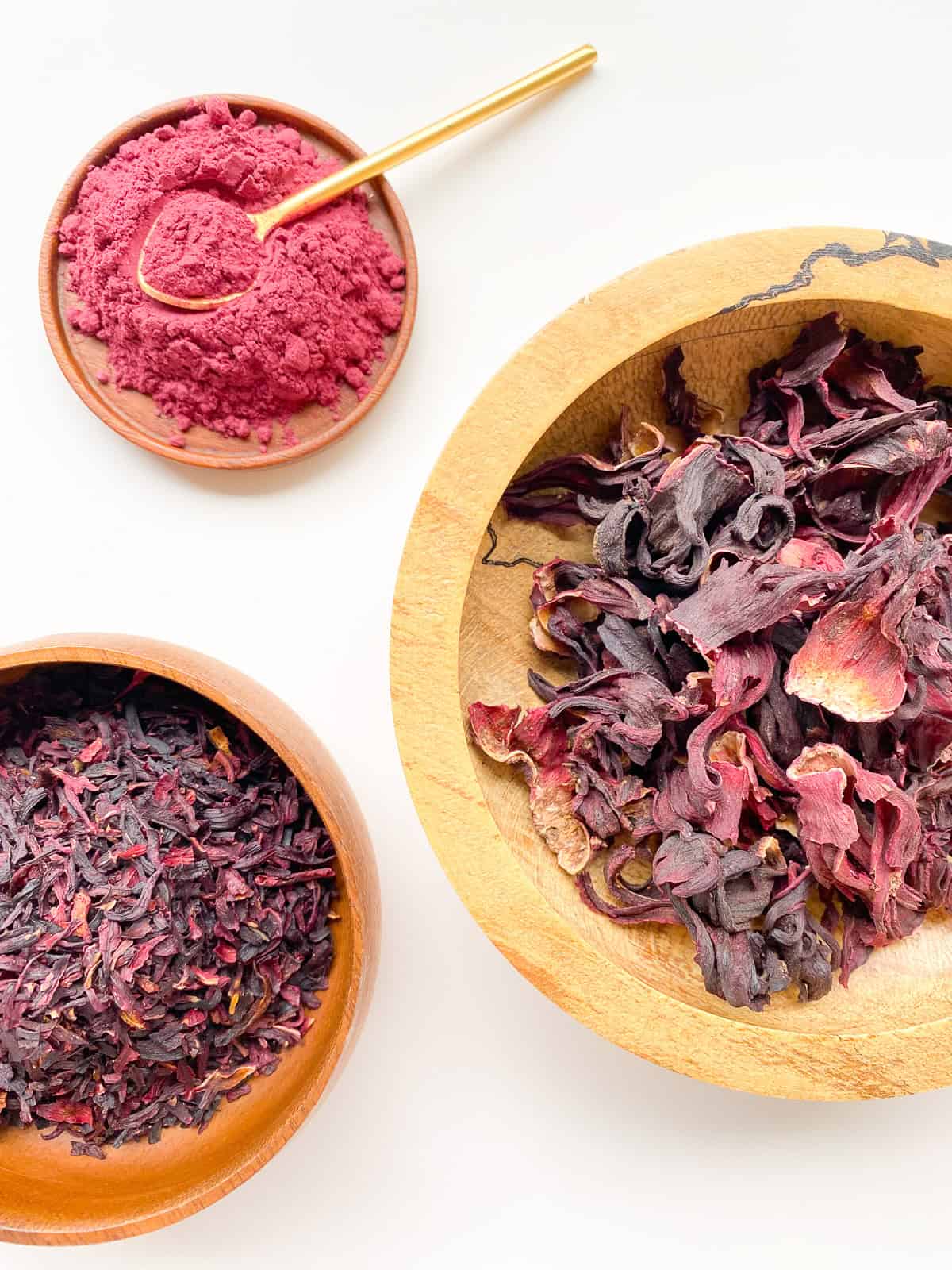 An image of three different varieties of dried hibiscus: ground, whole, and pieces.