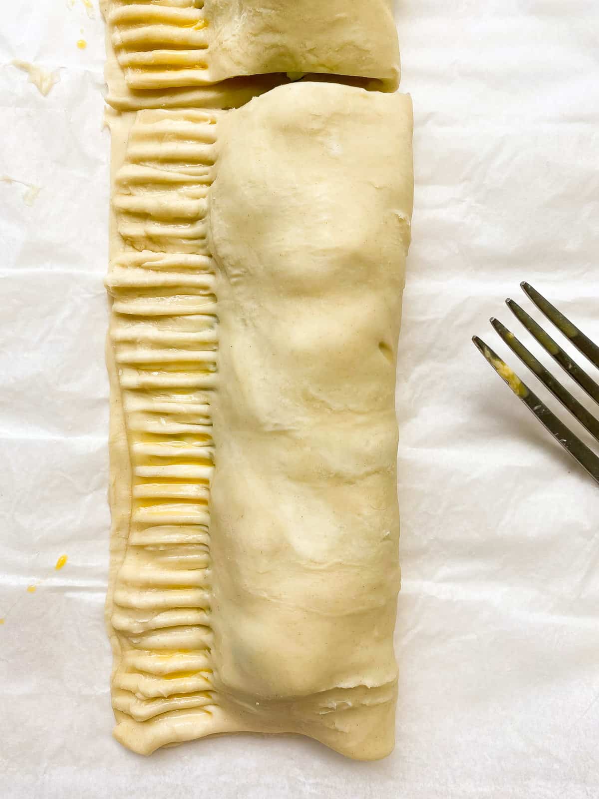 A close up image of pastry being crimped before baking.