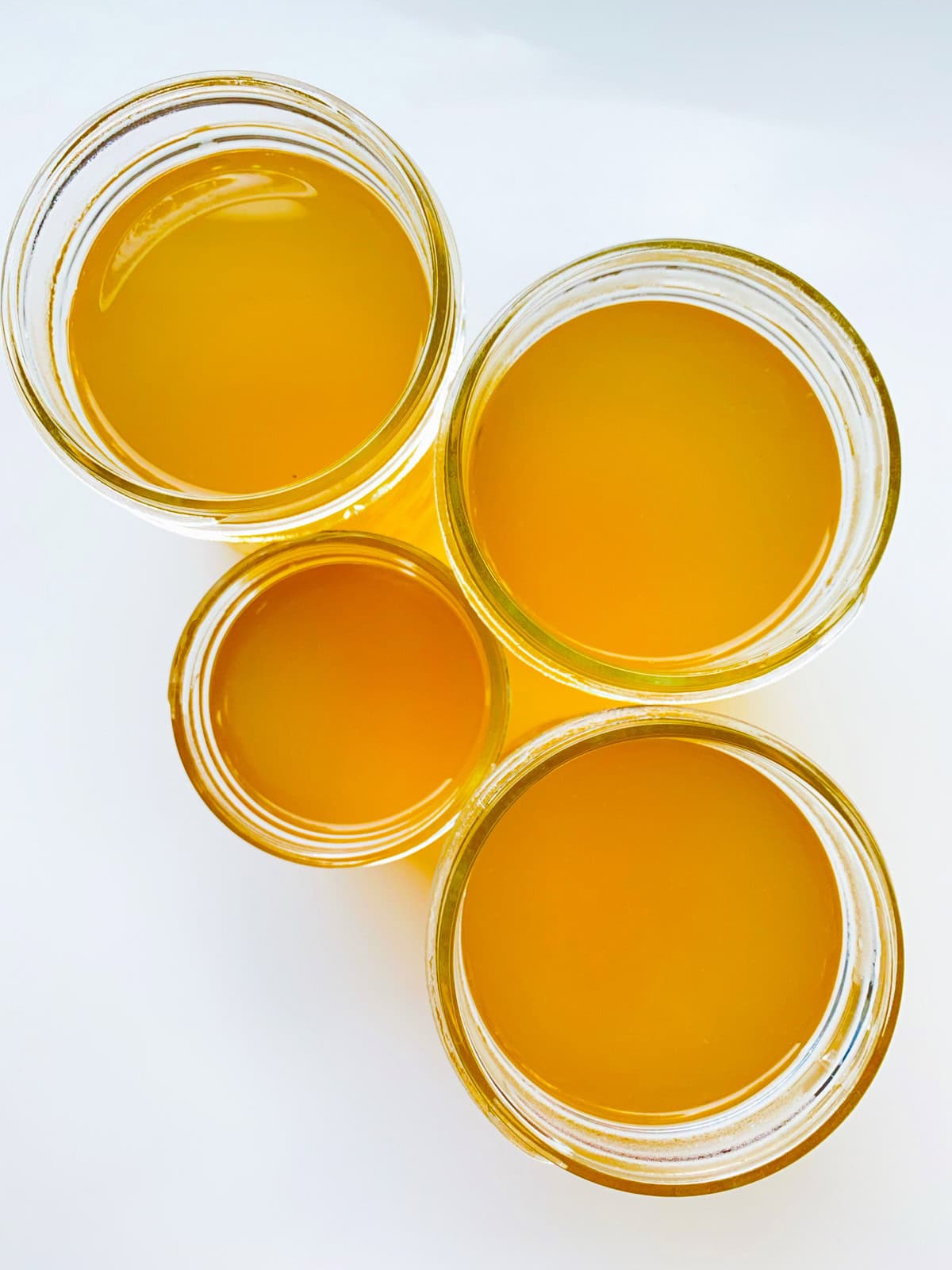 An image of four jars of corn broth.