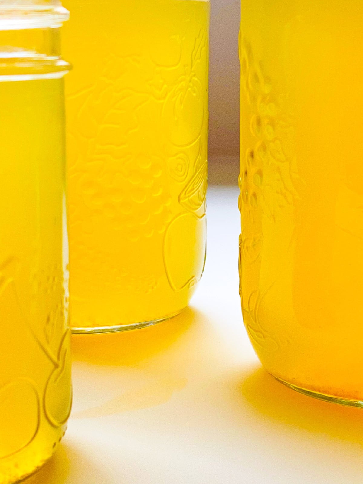 A close up image of jars of corn broth.