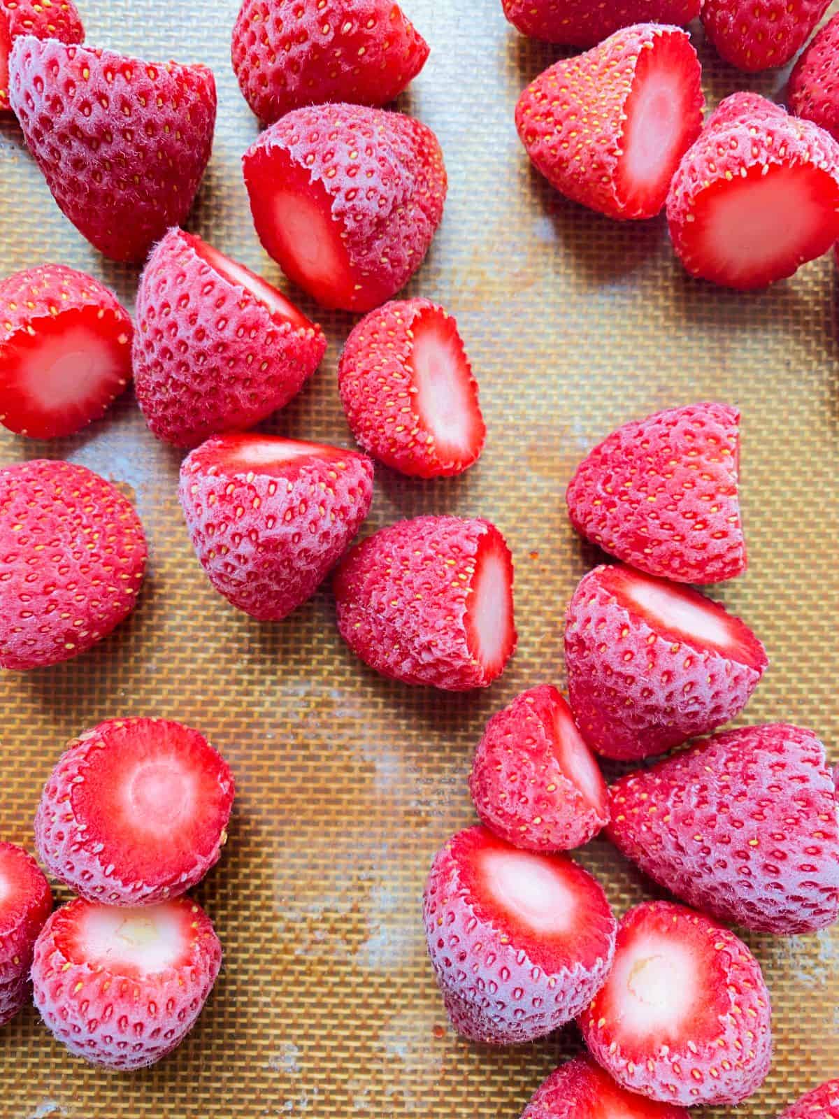 An image of frozen strawberries on a tray.