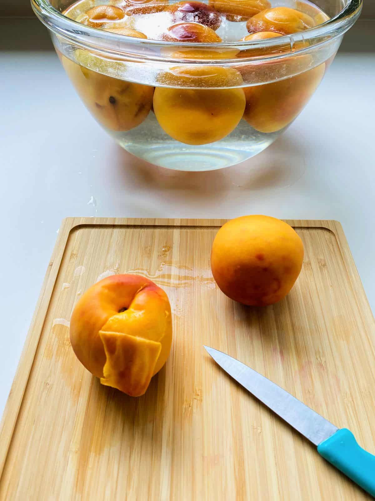 An image of peaches that have been blanched, waiting to be peeled before freezing.
