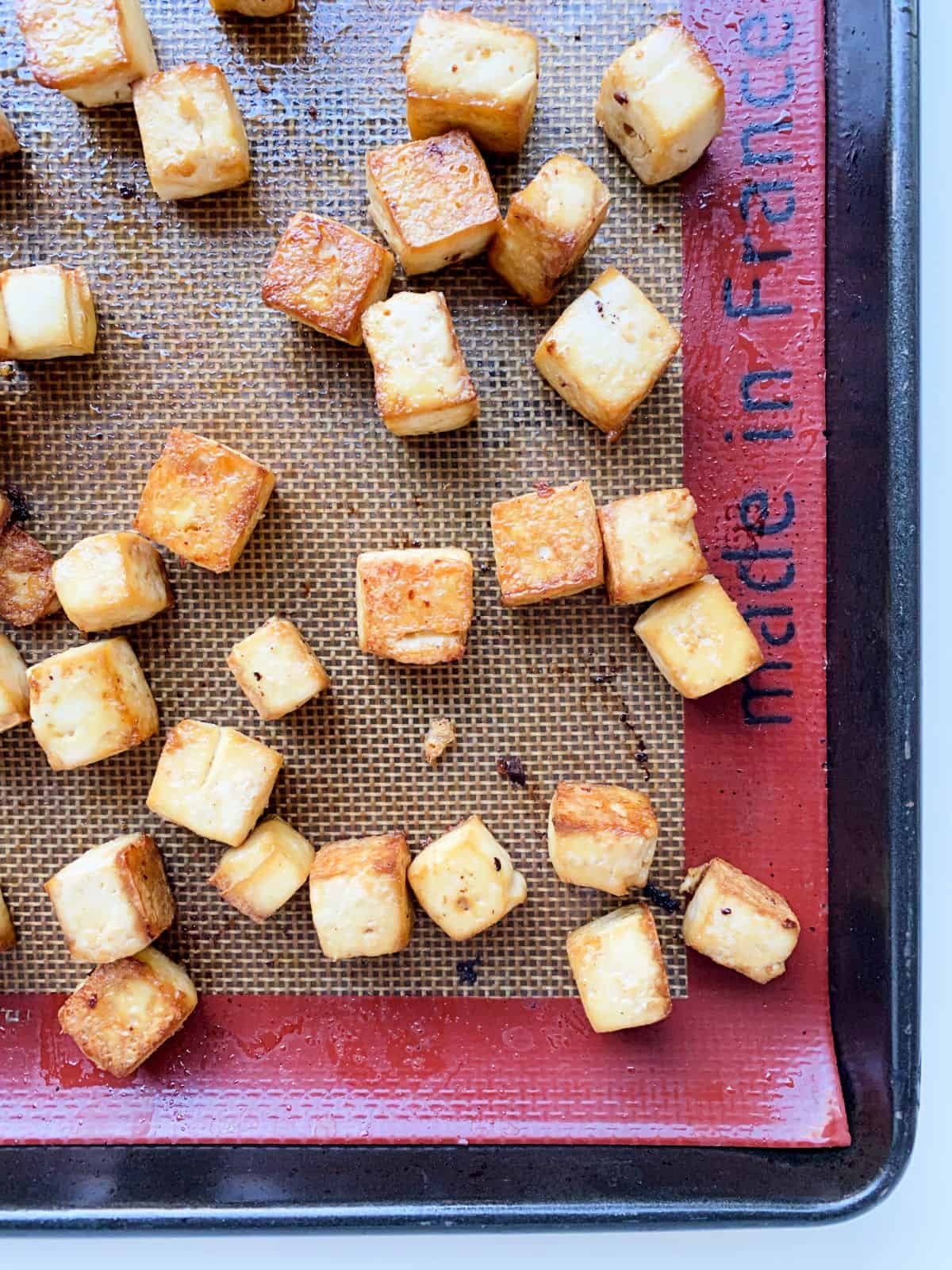 Essential Baked Tofu Cubes on a baking tray, just out of the oven.