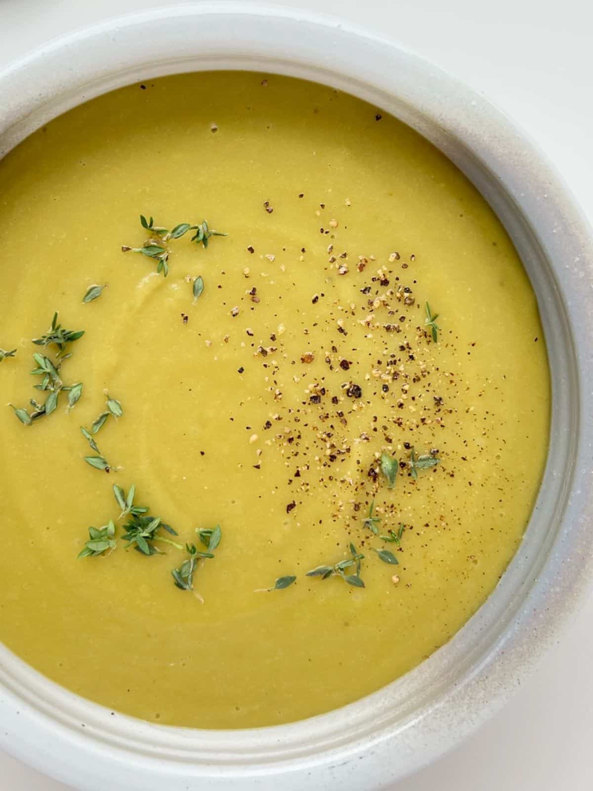 An image of Smoky Herbed Split Pea Soup in a white and grey ceramic bowl.