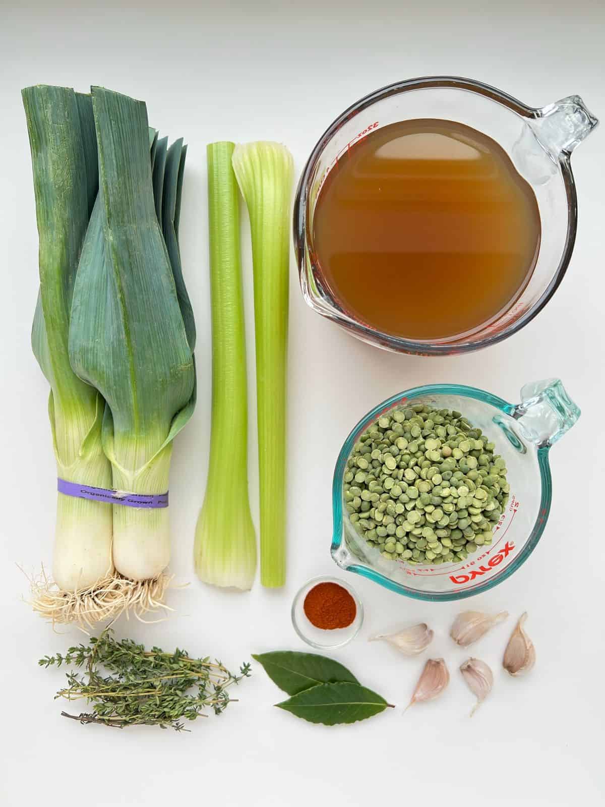 An image of the vegetable ingredients needed for Smoky Herbed Split Pea Soup laid out geometrically on a white countertop.