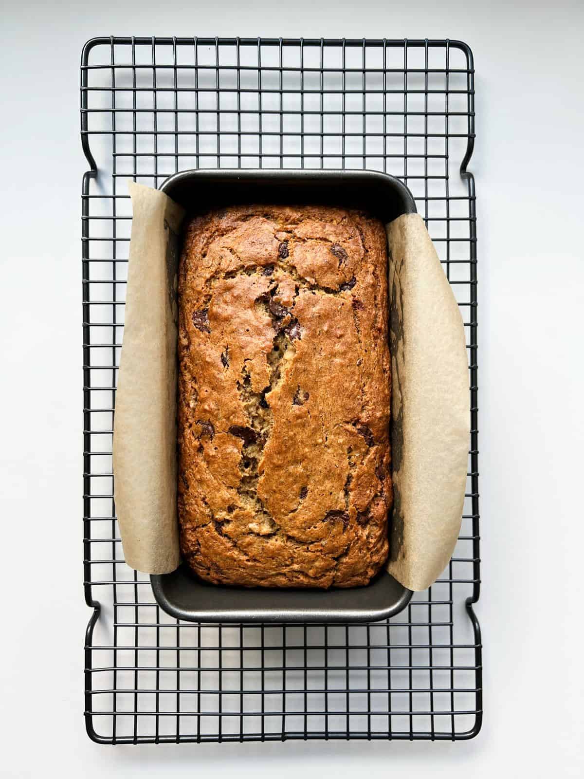 An image of Super Chocolatey Banana Bread sitting on a wire rack.