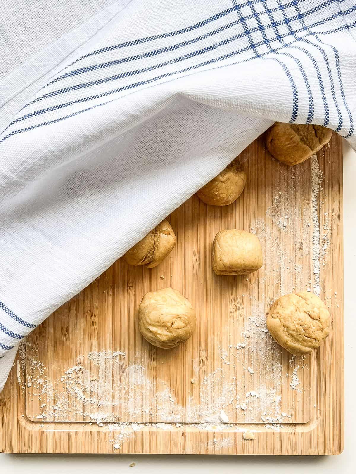 Balls of matzo dough, covered by a tea towel.