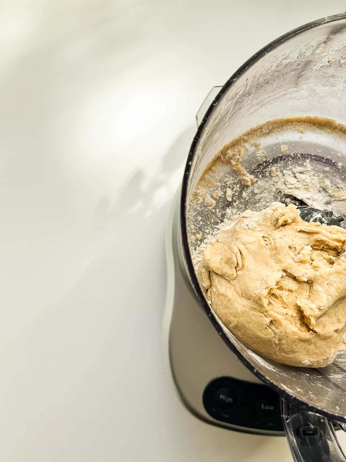 The inside of a food processor containing a ball of dough.