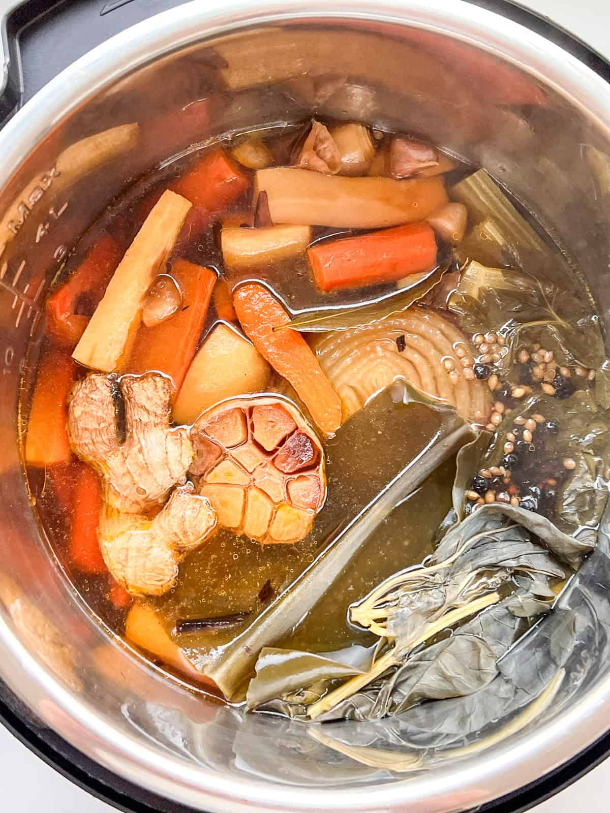 The ingredients for vegetarian broth inside an Instant Pot after cooking.