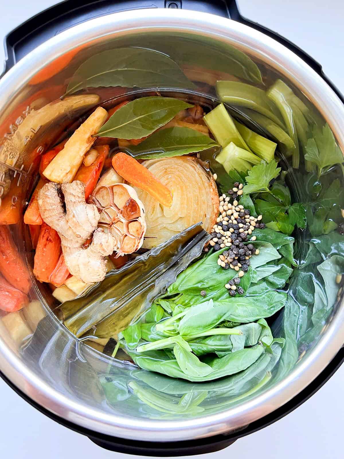 The ingredients for vegetarian broth inside an Instant Pot before cooking.