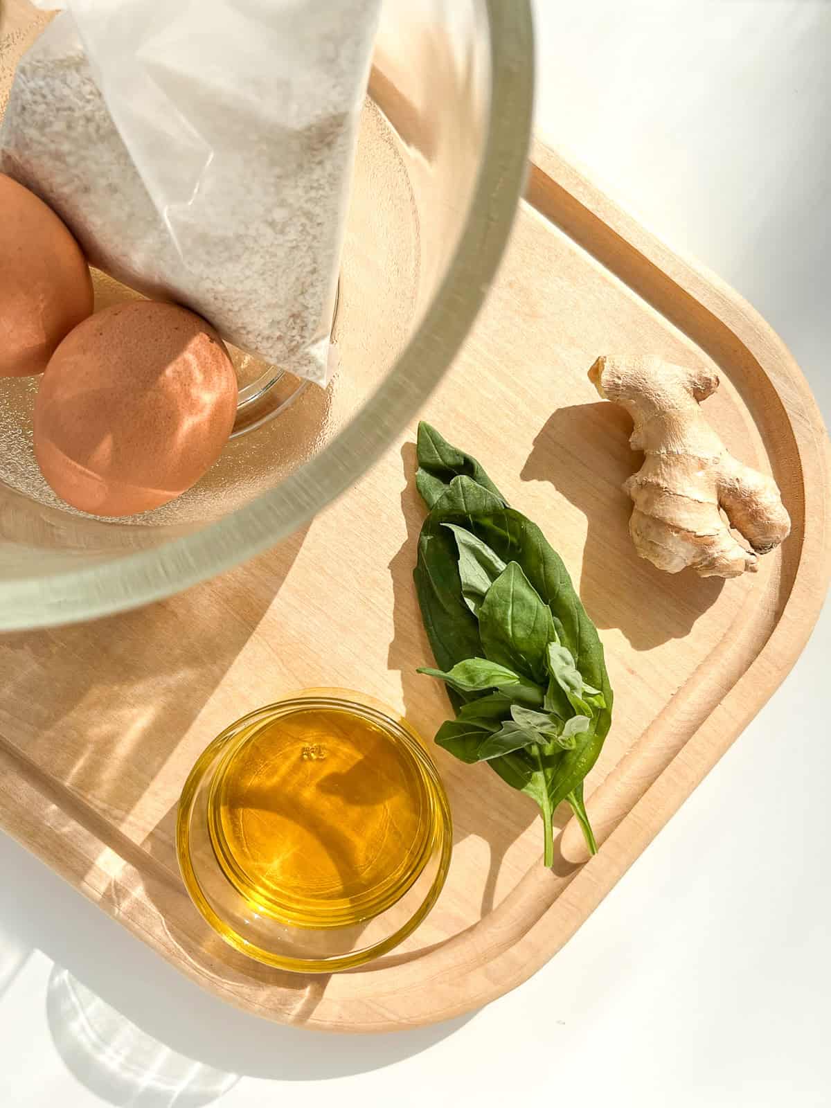 The ingredients needed for the matzo balls on a light wood cutting board.