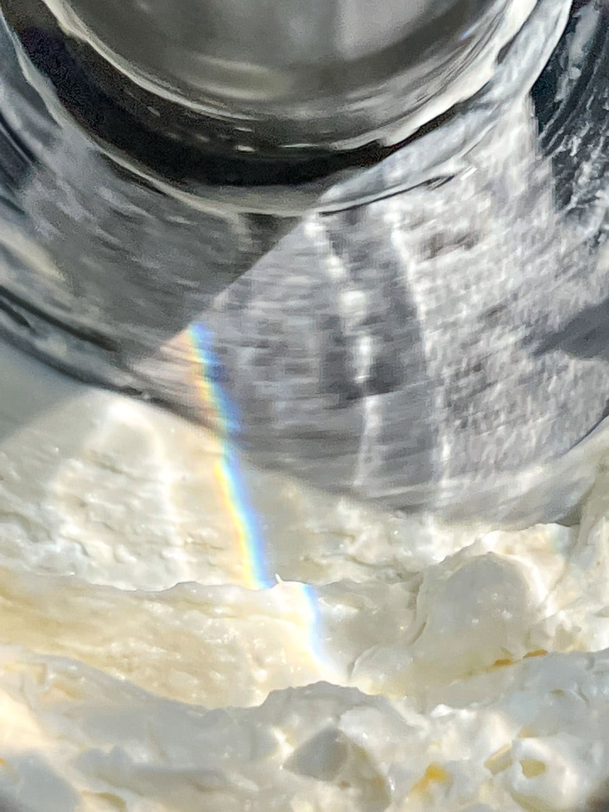 An image of feta, labneh, and garlic in the bowl of a food processor.
