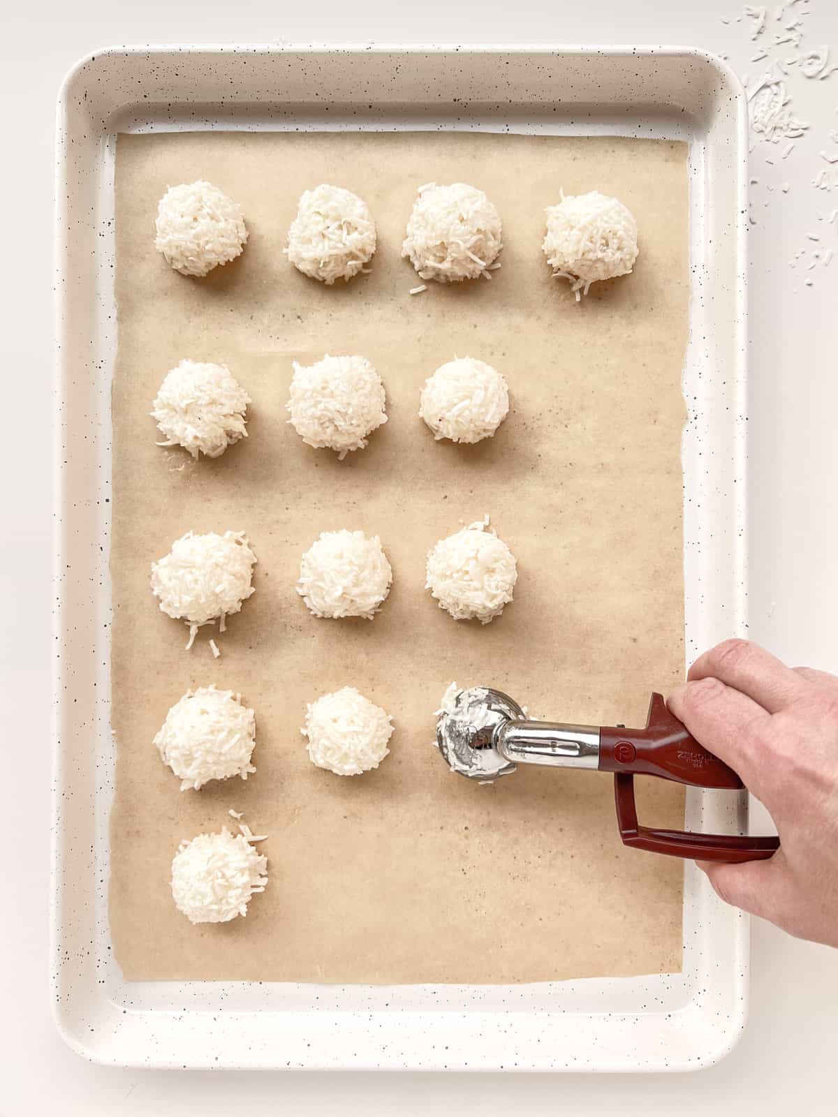 An image of the coconut mixture being scooped onto a baking sheet.