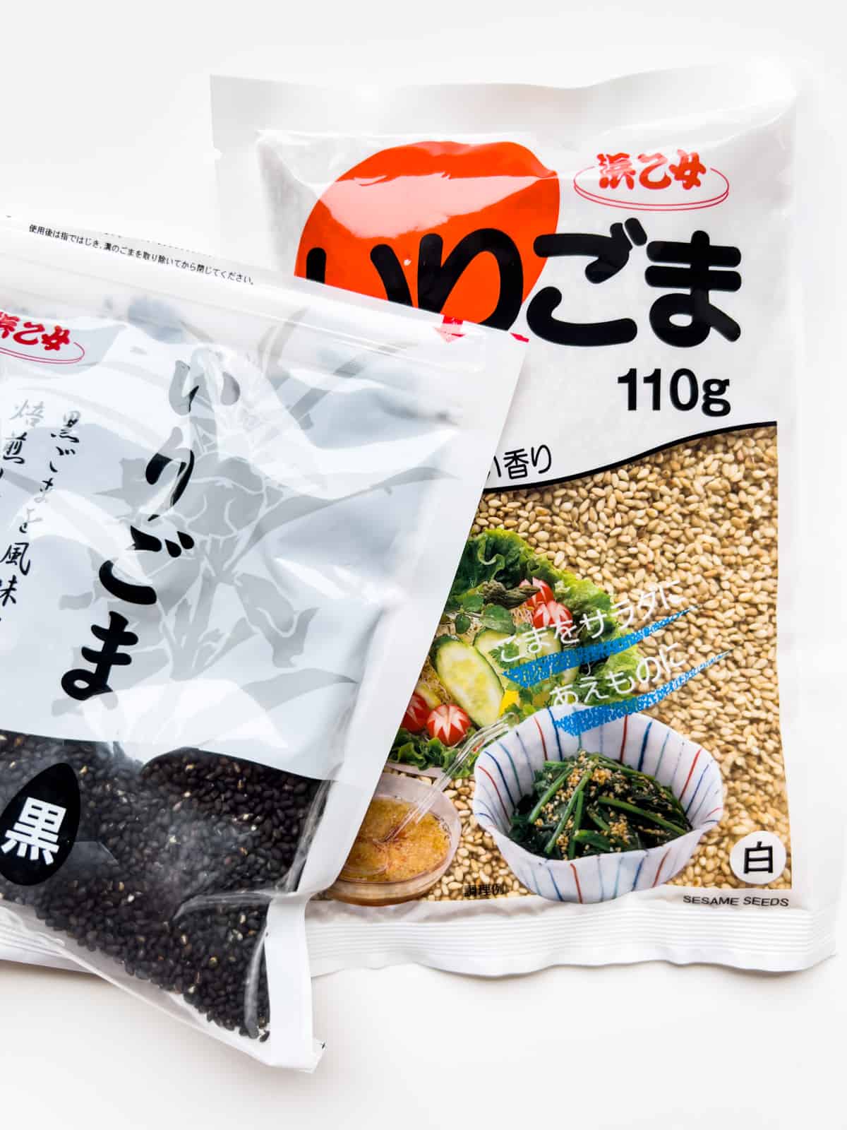 An image of two packages of sesame seeds, one containing white sesame seeds, the other black sesame seeds