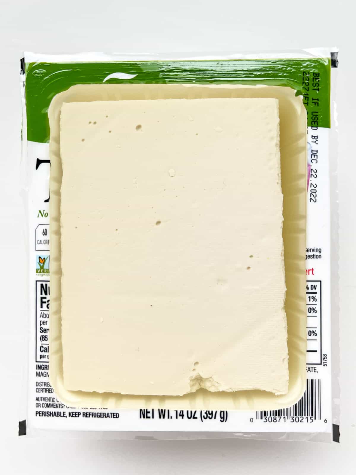 An image of tofu in its package with the lid removed.