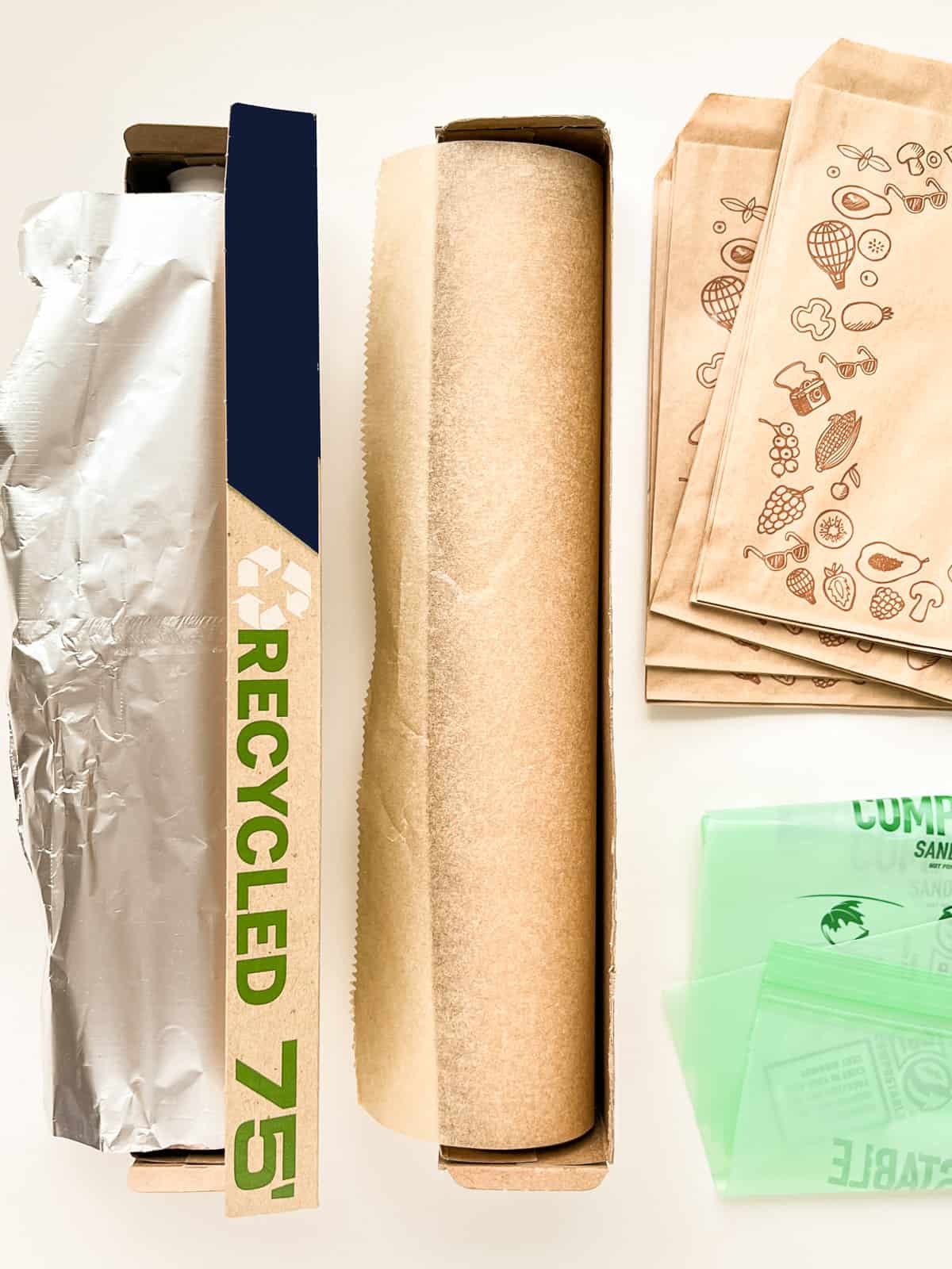 An image of a selection of recycled, recyclable, and compostable kitchen wrapping items including foi, parchment, paper bags and compostable plastic bags.
