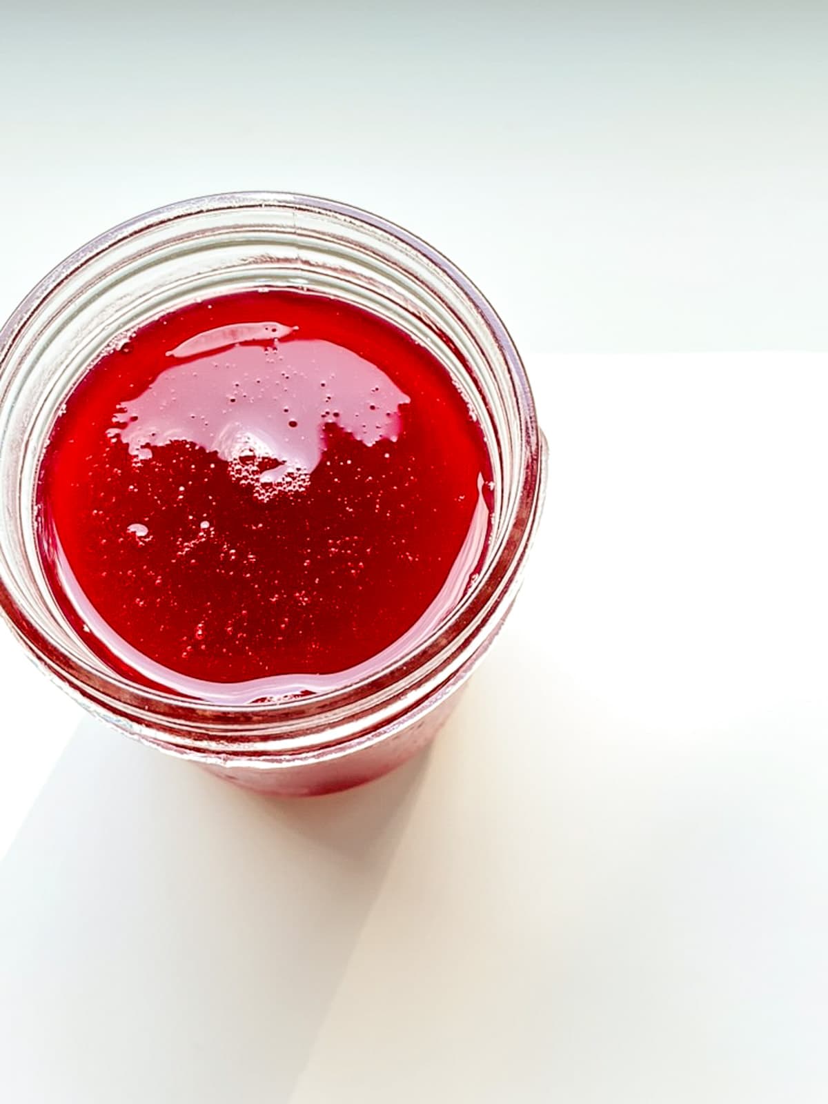 An image of rhubarb syrup in a glass jar.