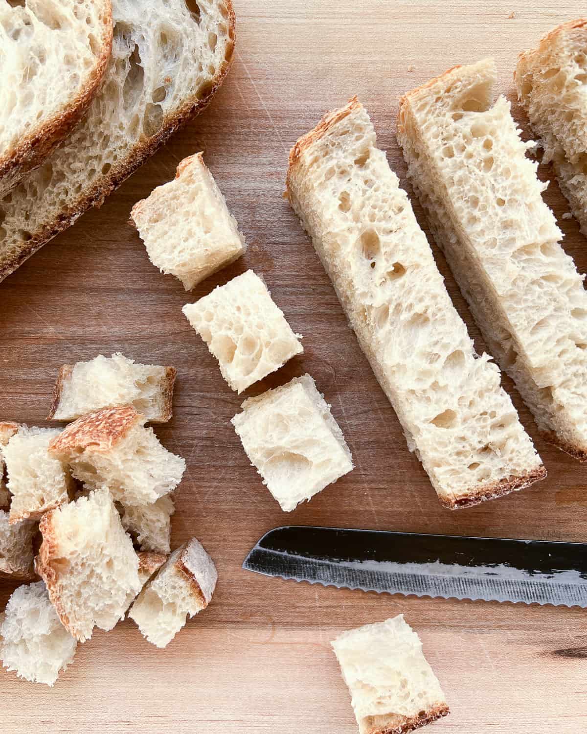 An image of sourdough bread being cut up in to cubes to be made into croutons.