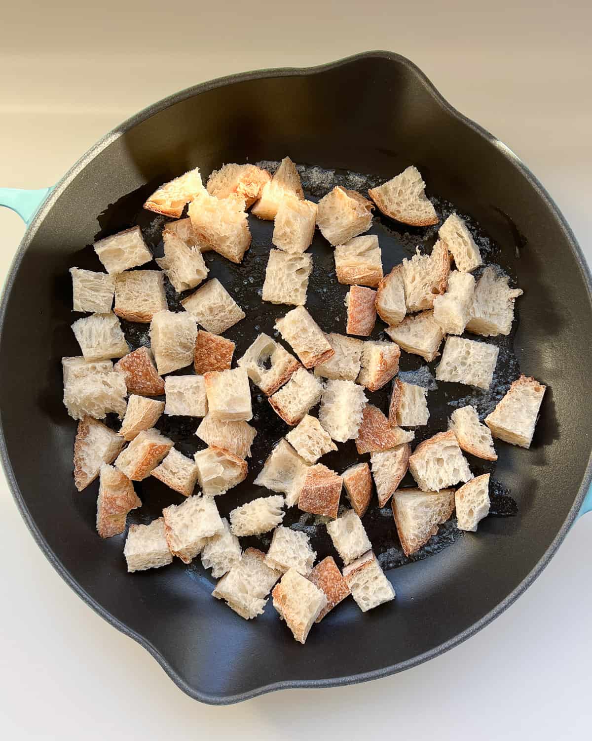 Bread cubes in a pan ready to be cripsed into croutons.