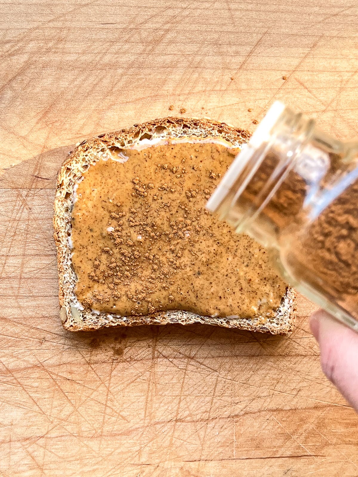 An image of cinnamon being sprinkled on toast.
