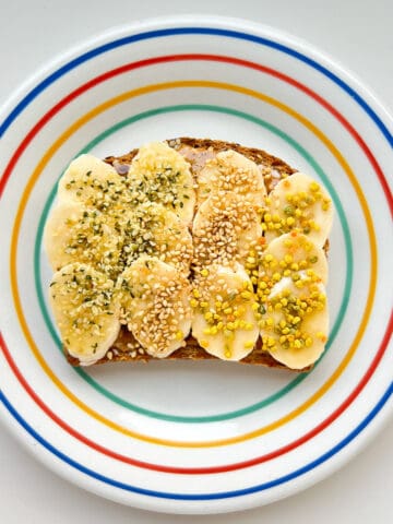 An image of banana supreme toast on a rainbow coloured plate.