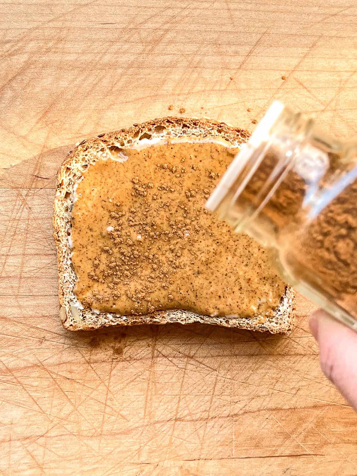 An image of cinnamon being sprinkled on toast.