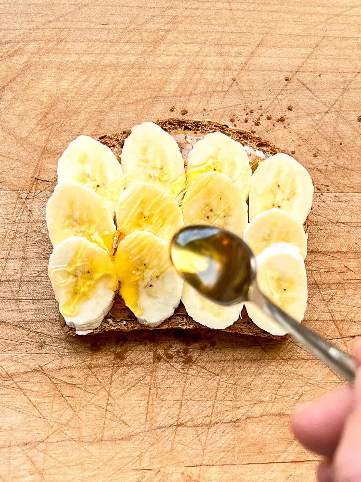 An image of honey being drizzled on toast.