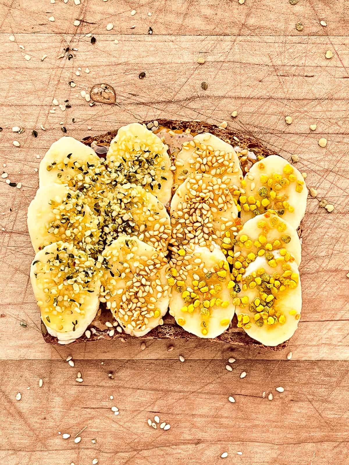 An image of a completed slice of banana supreme toast on a wooden cutting board.