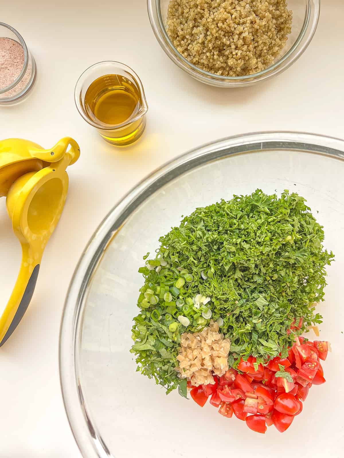 The ingredients for tabbouleh in a glass mixing bowl.