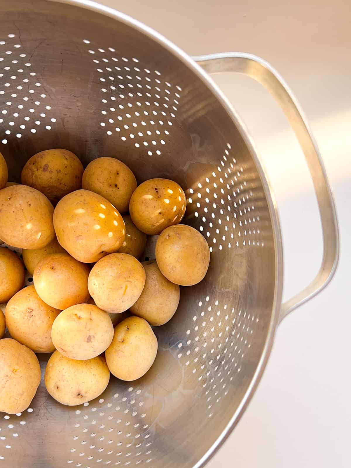 An image of boiled potatoes drying in a collander.