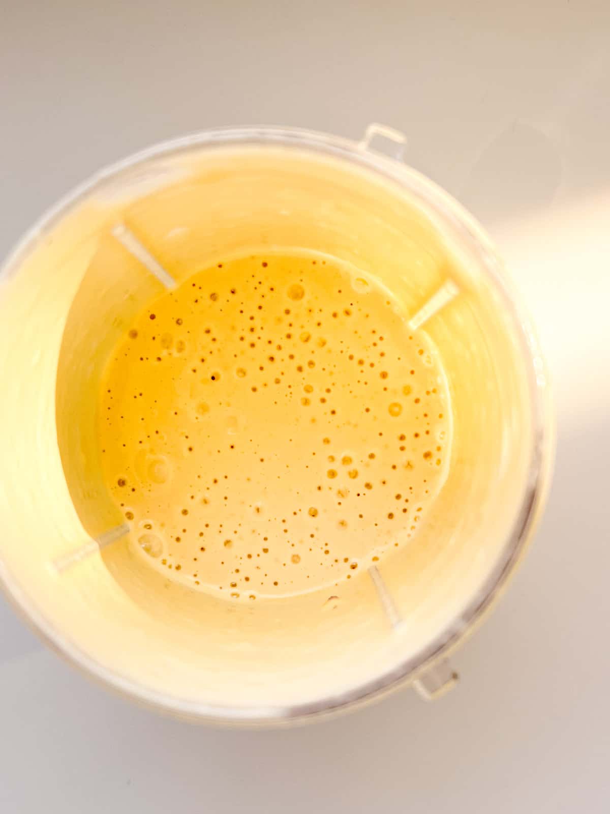 An image of blended tahini sauce in a bullet style blender canister.