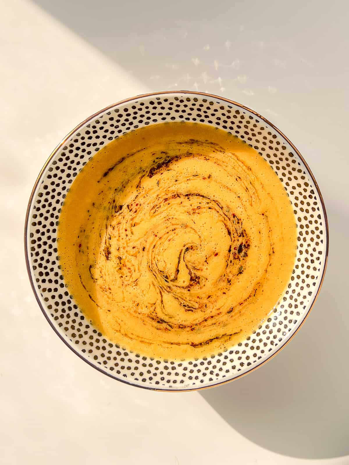 An image of lentil soup topped with sumac and mint butter.