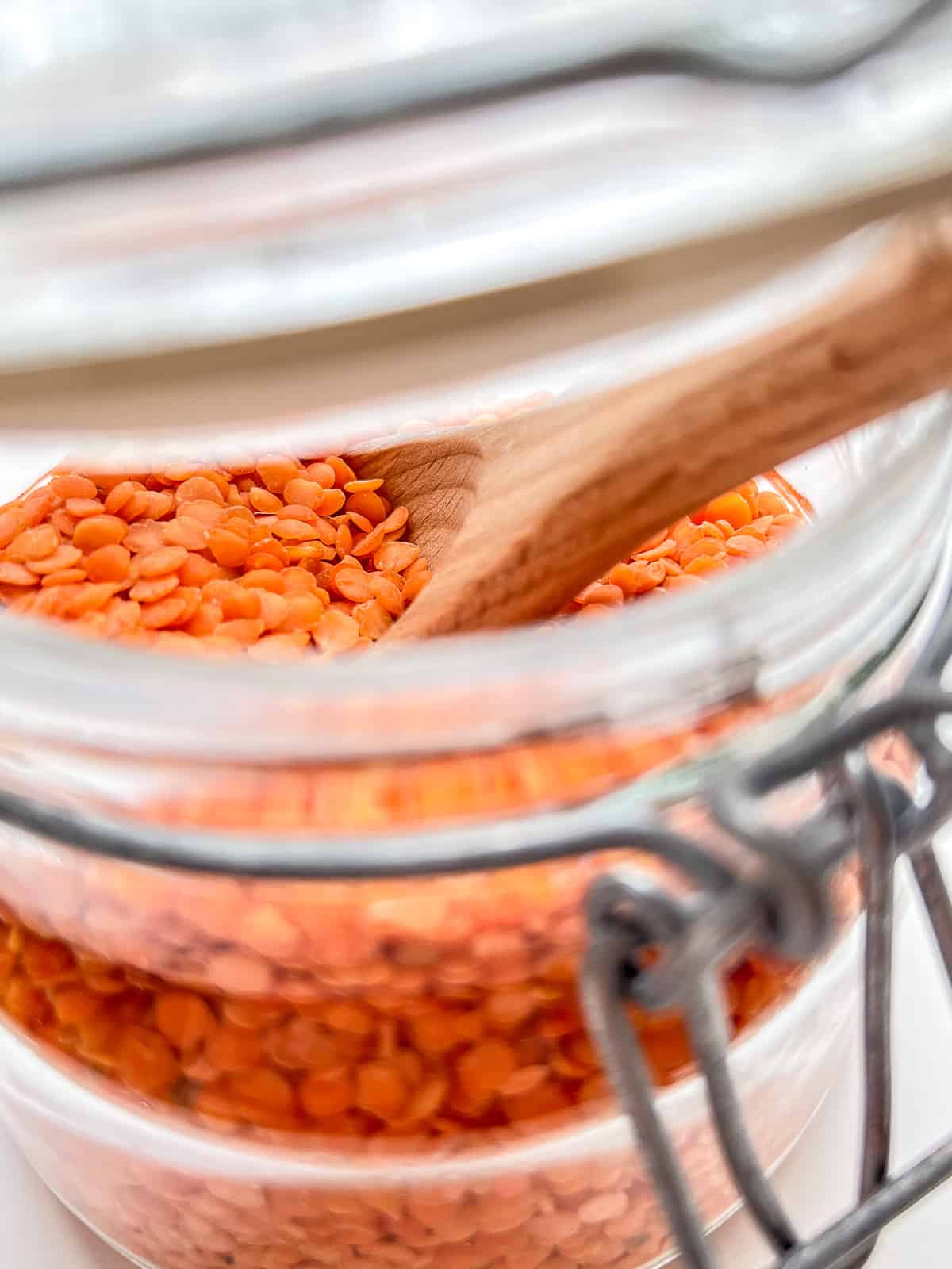 An image of red lentils in a small glass jar.