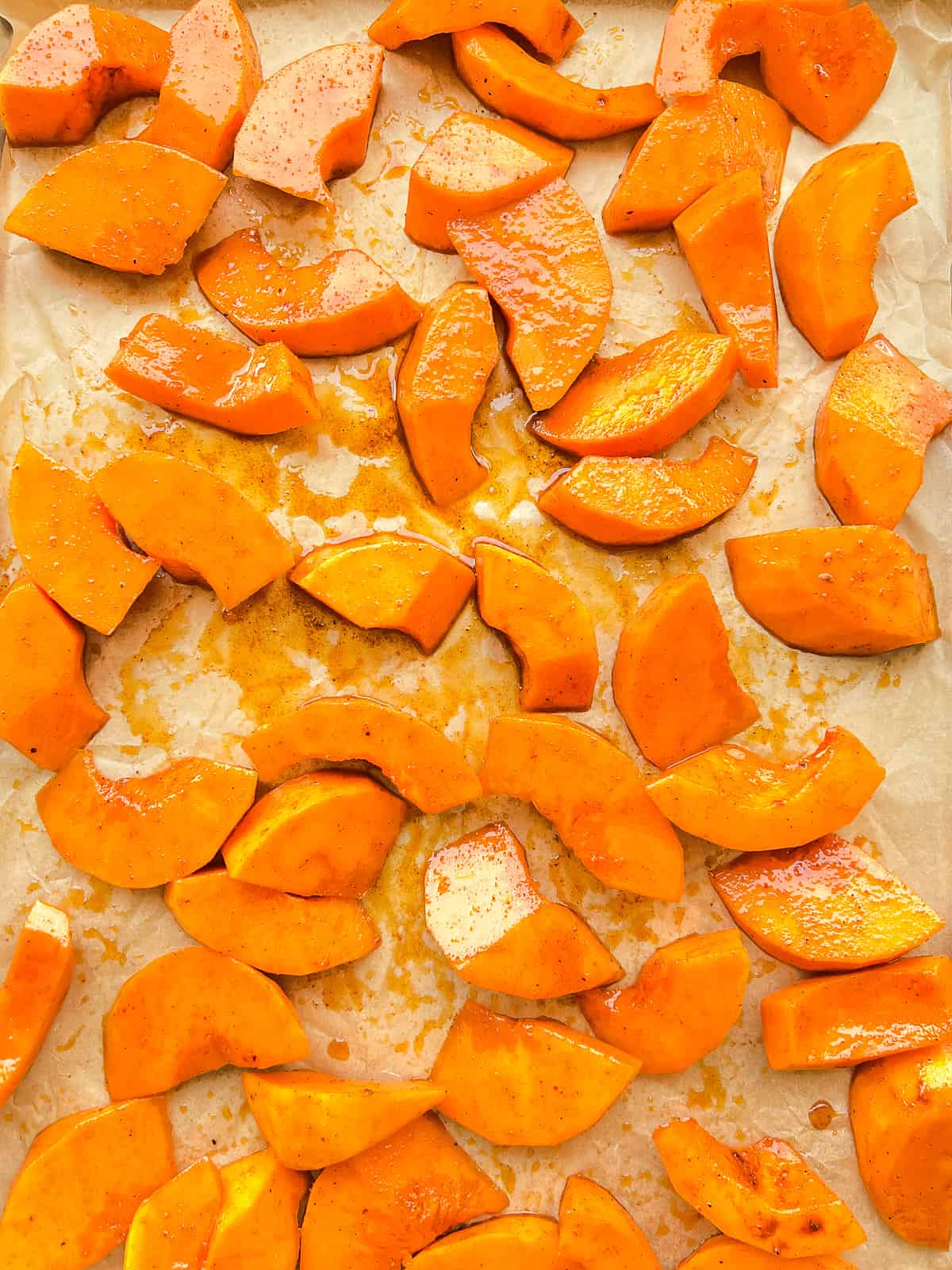 An image of prepared squash before it is roasted on a roasting tray.