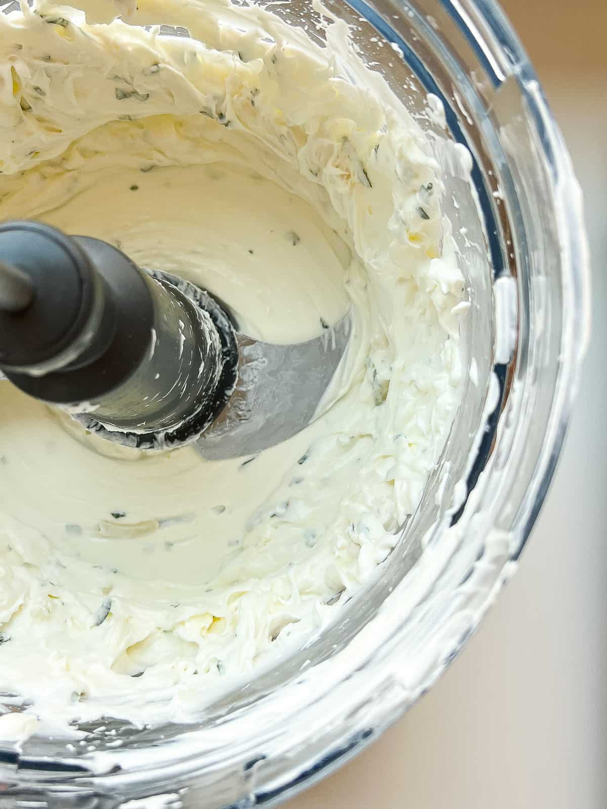 The finished labneh mixture in the bowl of a food processor.