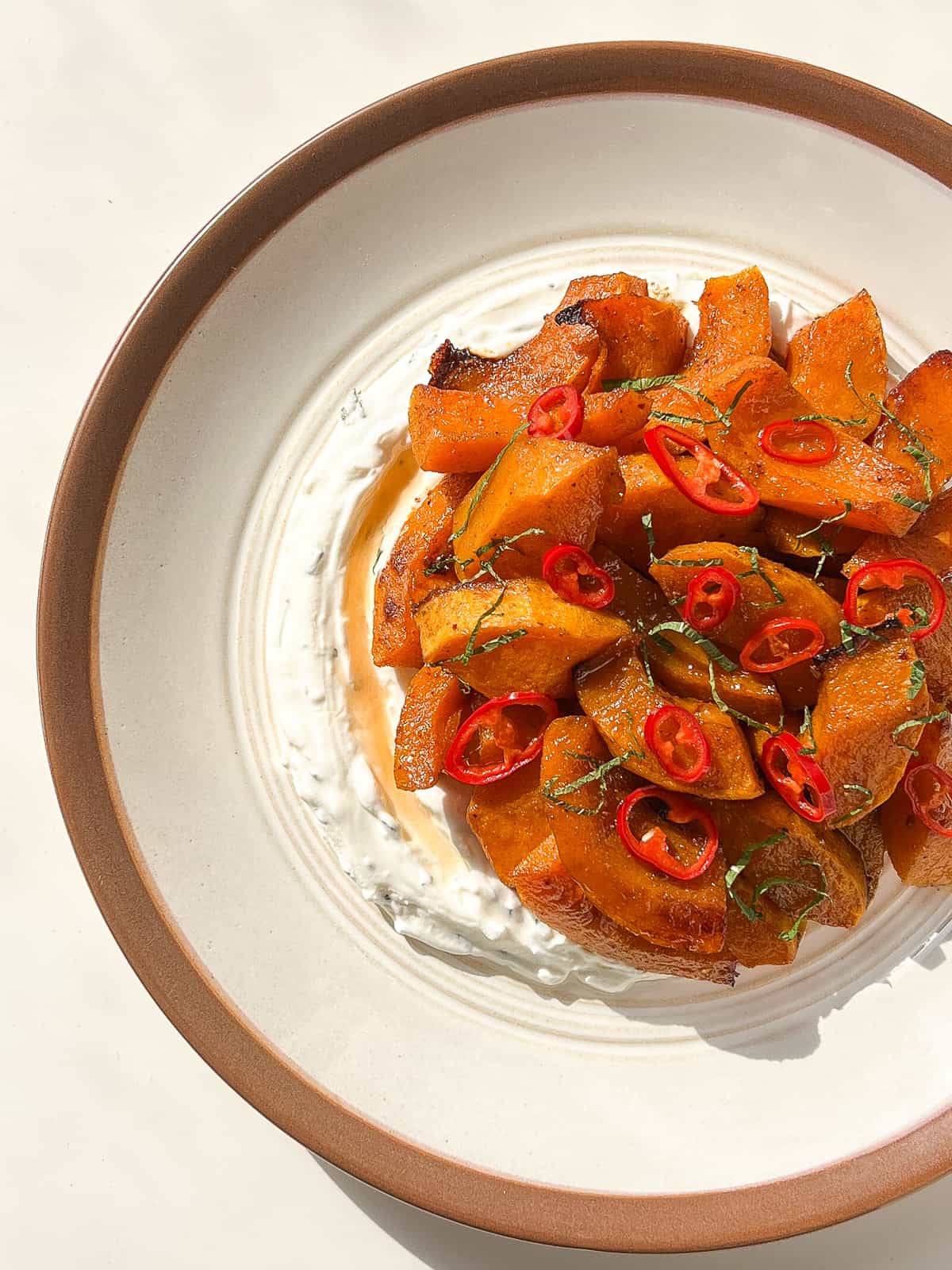 An image of roasted squash topped with pickled chillies.