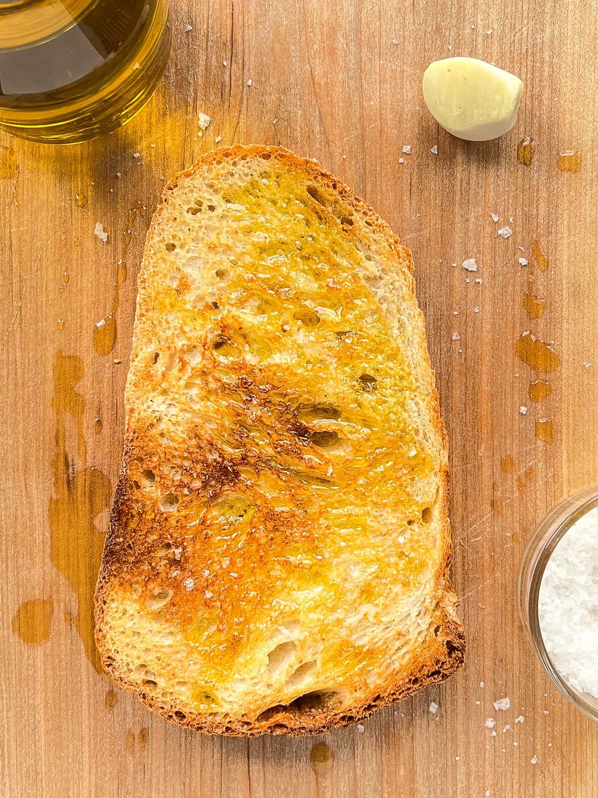 An image of golden garlic toast on a wooden cutting board.