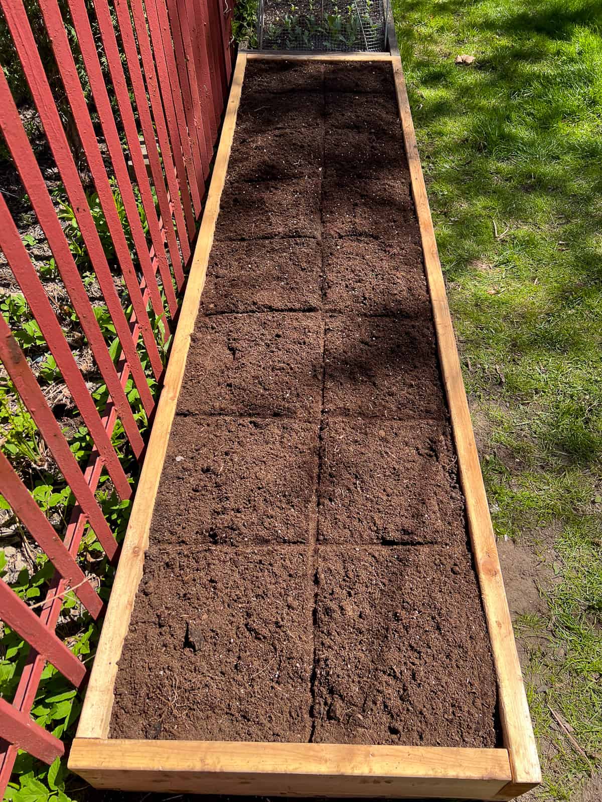 An image of a raised bed filled with soil and divided into square foot plots as part of the Square Foot Garden method.