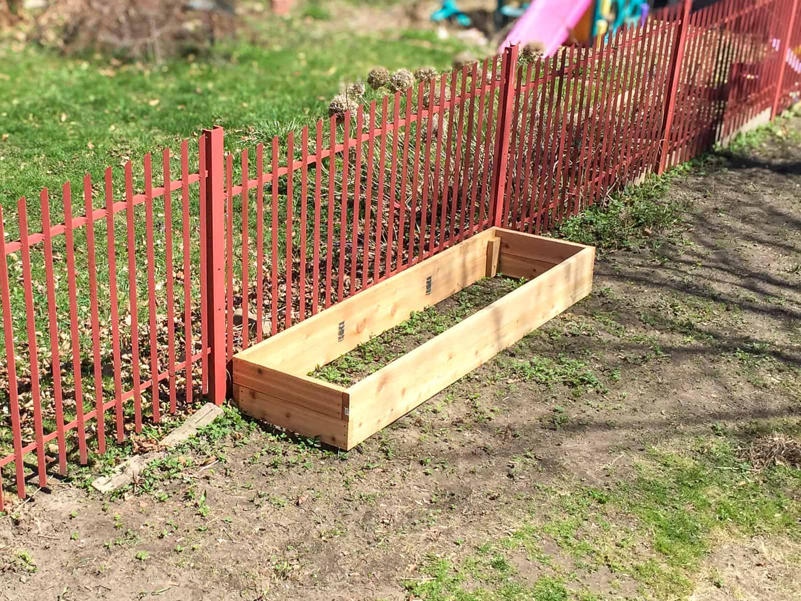 An image of a raised bed, not yet filled with soil, sitting in a backyard, soon to be used with the Square Foot Garden method.