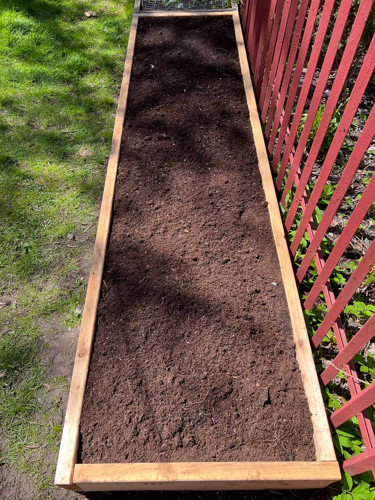 An image of a raised bed filled with soil.