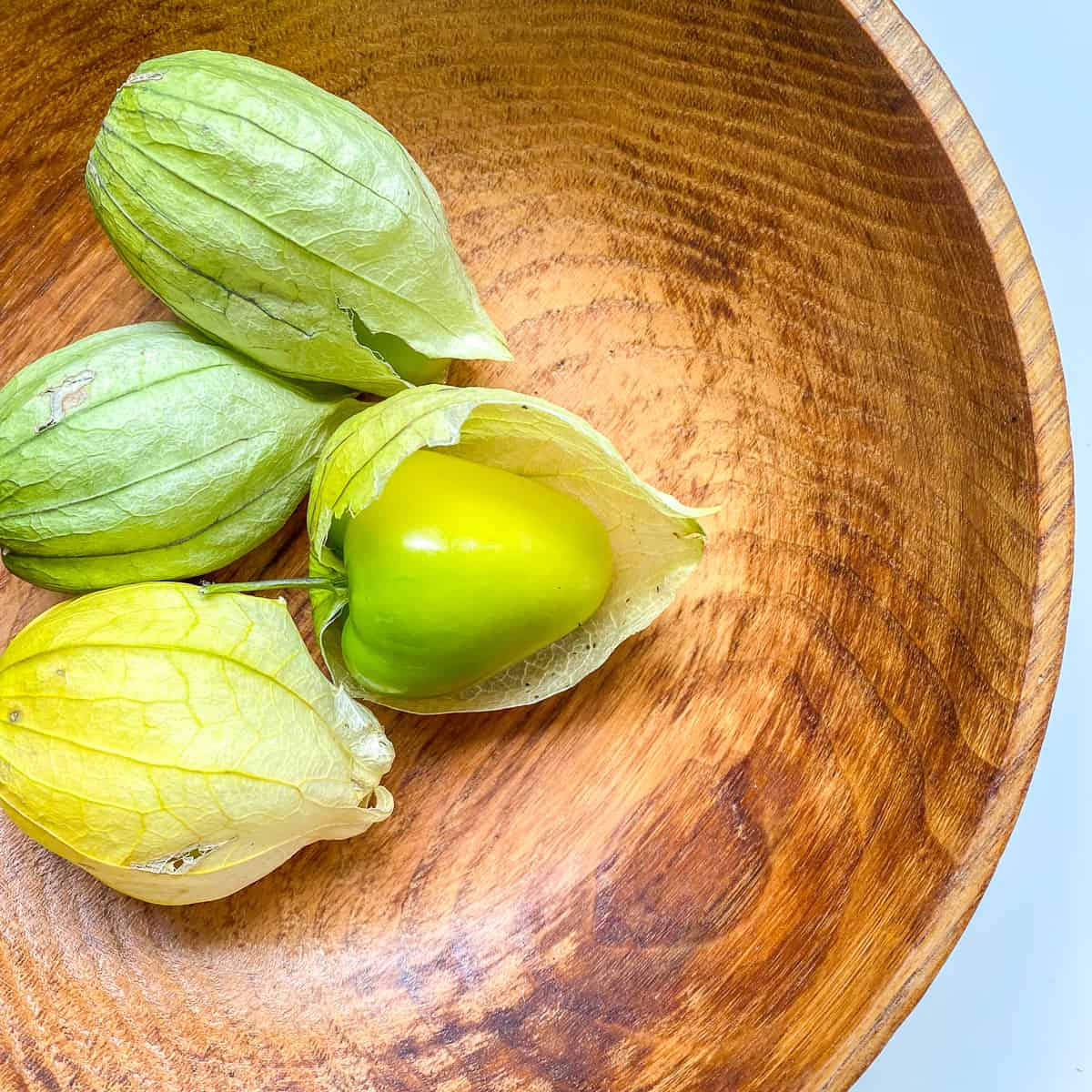 A bowl filled with tomatillos.