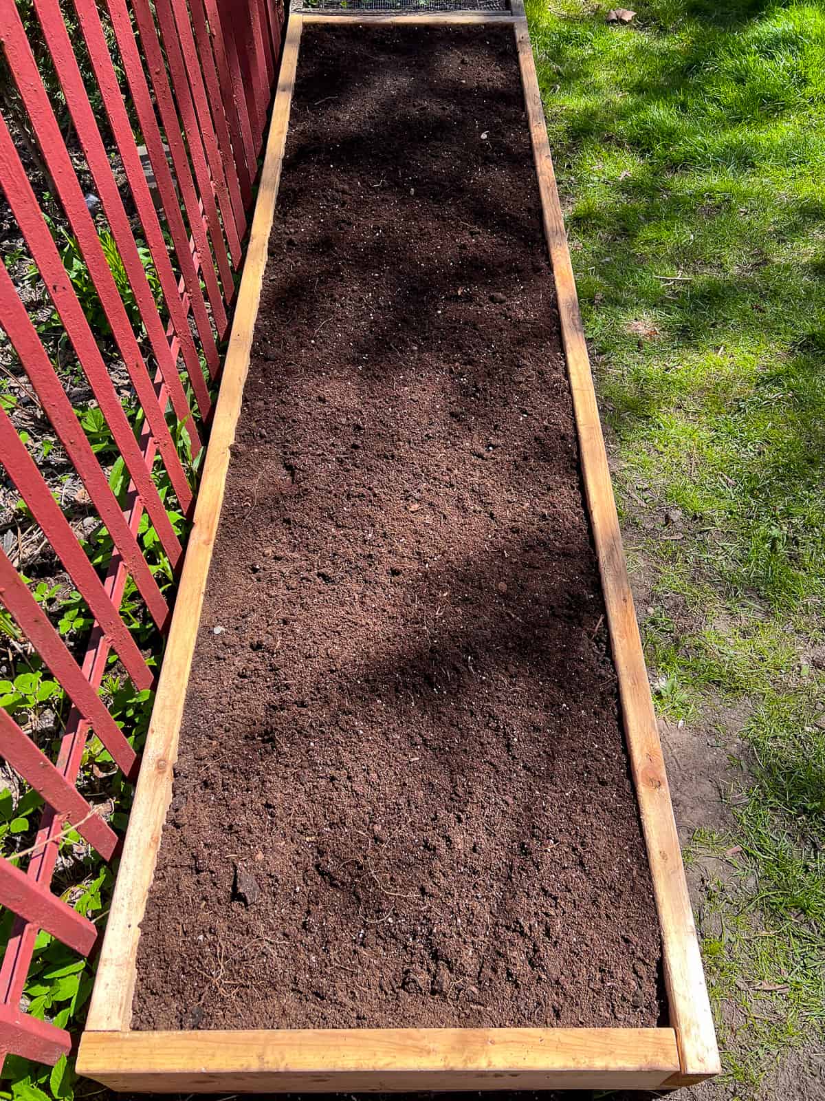 An image of a raised bed filled with soil.