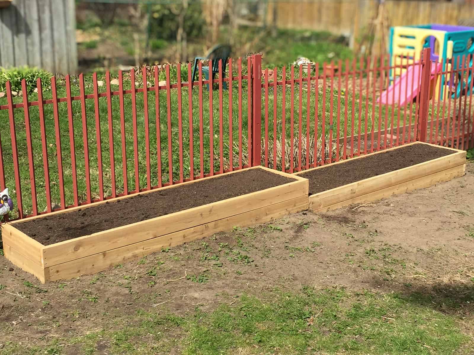 An image of two raised garden beds filled with soil but not yet planted.