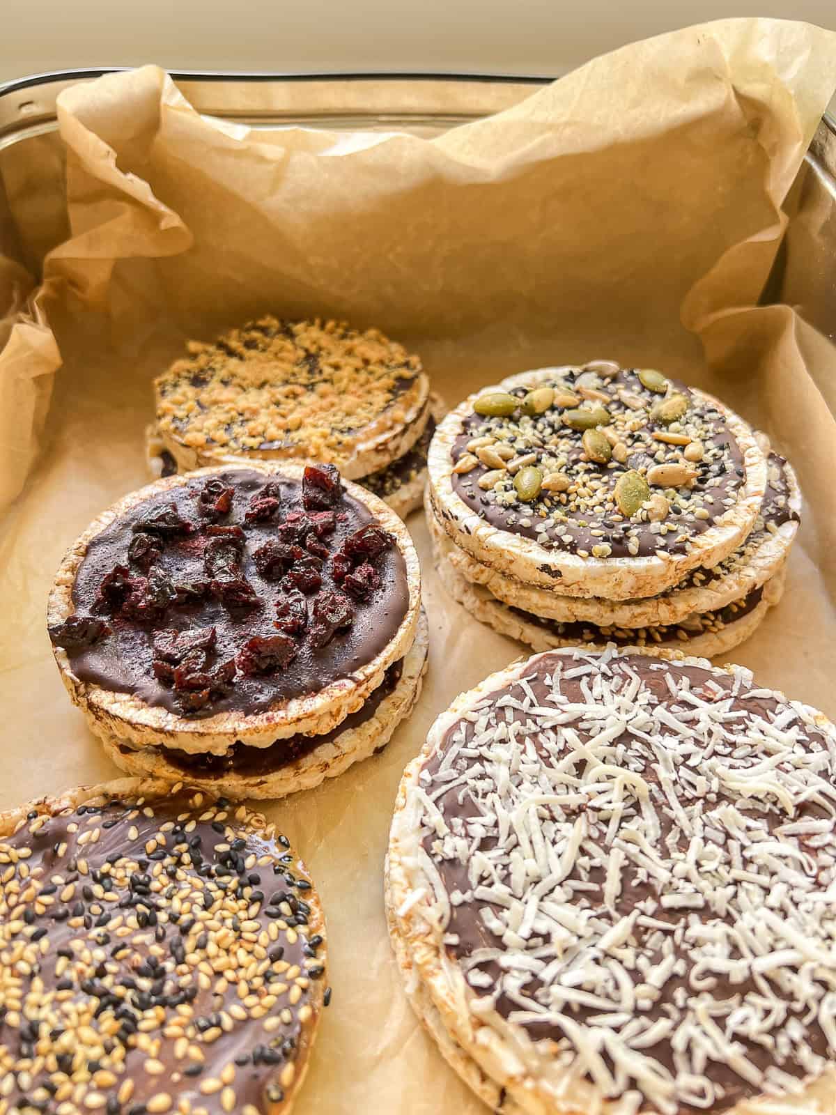 An image of a variety of homemade Chocolate Rice Cake Treats in a parchment paper lined tin.