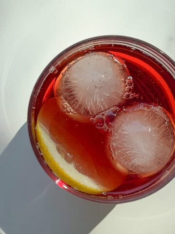 An image of a glass cup filled with Rooibos and Grape Iced Tea.