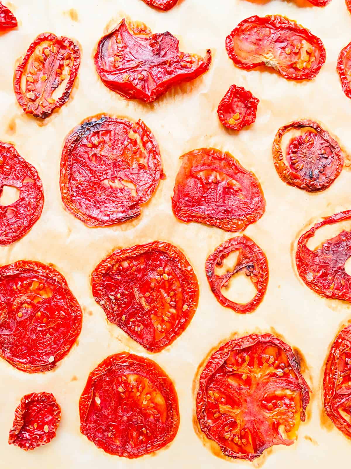 An image of dried tomato slices on parchment paper.